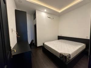 um pequeno quarto com uma cama num quarto em Victoria Hotel em Ho Chi Minh