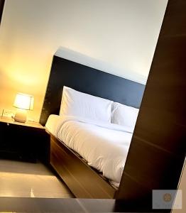 a bedroom with a white bed with a blue headboard at Ta' Tereża Seafront Apartments in St. Julianʼs