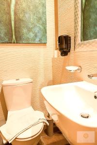 a bathroom with a toilet and a sink at Ta' Tereża Seafront Apartments in St. Julianʼs