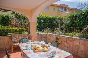 a table and chairs on a patio with a stone wall at Home Garden in Cala Gonone
