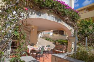 an archway with a table and chairs and flowers at Home Garden in Cala Gonone