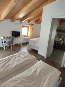 een slaapkamer met 2 bedden en een bureau bij B&B Vivi l'Attimo in Campodenno