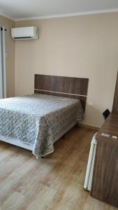 1 dormitorio con 1 cama y suelo de madera en Hotel Beira Rio, en Piraju