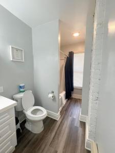 a white bathroom with a toilet and a shower at Triple Play Apt 1 All Star Baseball Rentals in Oneonta +16 photos