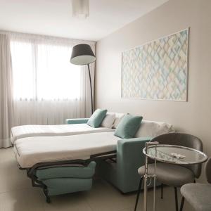 a hotel room with a bed and a chair at Hotel & Spa Real Ciudad De Zaragoza in Zaragoza