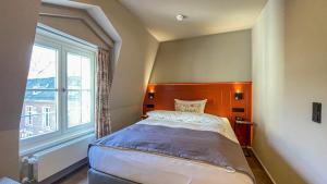 デュッセルドルフにあるBoutique Hotel Orangerieの大きな窓のあるベッドのある寝室