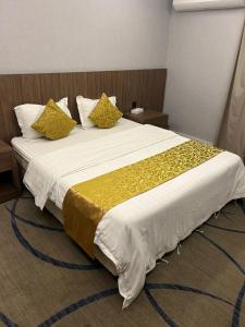 1 dormitorio con 1 cama grande con almohadas amarillas en فندق سما السعوديه en Riad