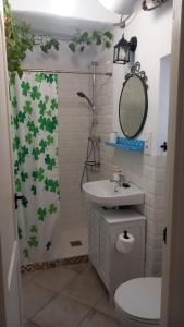 a bathroom with a shower curtain with a toilet and a sink at La Casa del Callejón in Vejer de la Frontera +13 photos
