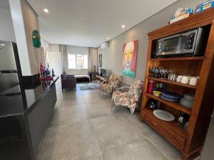 a living room with a kitchen and a living room with chairs at CASA DE CONDOMINIO Praia Juquehy Conforto e Tranquilidade in São Sebastião