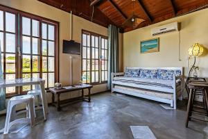 - un salon avec un lit et une table dans l'établissement Casa rústica com vista mar no Campeche TOCA151, à Florianópolis