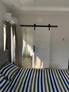1 dormitorio con 1 cama y puerta corredera de cristal en Solaris 2: Peaceful Condo close to Tourist Spots, en Corinthe