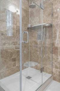 um chuveiro com uma porta de vidro na casa de banho em The Mayfair King em Londres
