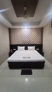 een slaapkamer met een bed met twee witte schoenen erop bij Omm Palace in Puri