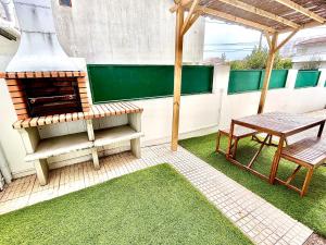 d'une terrasse avec un barbecue, une table et un banc. dans l'établissement Carcavelos Summer Beach, à Carcavelos