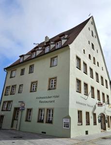 un grand bâtiment blanc avec un toit marron dans l'établissement Hotel Andreasstuben, à Weißenburg in Bayern