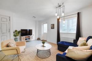 a living room with a couch and chairs and a tv at Stylish 3 Bed in Central London - Garden in London