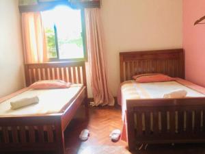 two twin beds in a room with a window at Nieta Chunu in Dar es Salaam