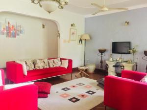 a living room with a red couch and a tv at Nieta Chunu in Dar es Salaam