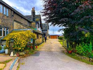 a cobblestone street in an old house with yellow flowers at New Hall, Elland in Elland