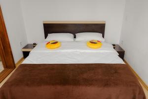 a bedroom with a bed with two yellow hats on it at Business Transit to Therme & Bucharest Airport in Săftica