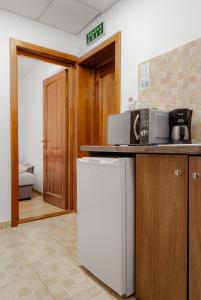 a kitchen with a counter with a microwave and a refrigerator at Business Transit to Therme & Bucharest Airport in Săftica