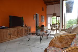 a living room with a tv and a coffee table at Casa próxima ao mar e montanha in Ilhabela