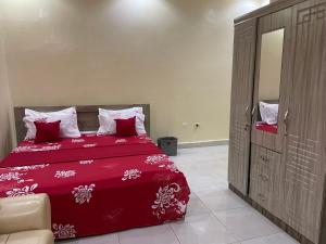 a bedroom with a red bed and a mirror at Charmante petite villa aux Mamelles in Ouakam