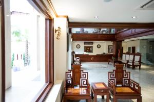 a room with chairs and tables and a large window at Capitol Residence in Vientiane