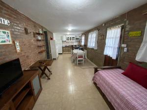 1 dormitorio con cama y pared de ladrillo en Buena Vista Icho Cruz en Villa Icho Cruz