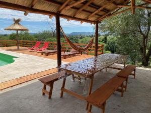 un patio con mesa, sillas y hamaca en Buena Vista Icho Cruz en Villa Icho Cruz