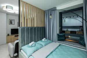 um quarto com uma cama com lençóis azuis e um espelho em Apartment EDIAS em Banská Bystrica