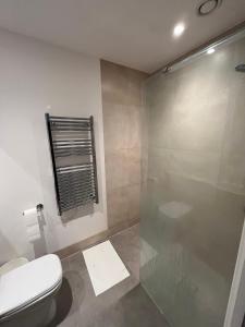 a bathroom with a toilet and a glass shower at The Nest Tottenham - cosy one bed apartment in London