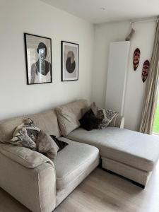 a living room with a couch and pictures on the wall at The Nest Tottenham - cosy one bed apartment in London