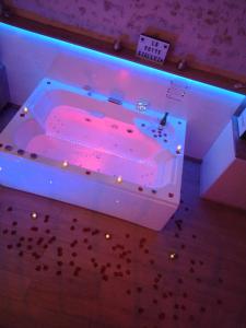 Habitación con bañera grande con iluminación rosa. en La Suite Etoilée - Balnéo privative, en Courgains 10 fotos más