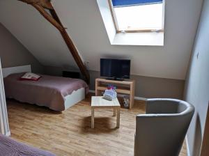 um quarto com uma cama, uma televisão e uma mesa em Le Vallon de Paray em Paray-le-Monial
