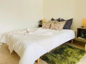 een wit bed in een slaapkamer met een groen tapijt bij Studio in the heart of city center in Luxemburg