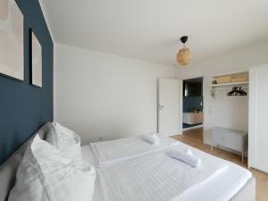 um quarto branco com uma cama com duas toalhas em 85qm, Parkplatz, zentral, großer Balkon, 2 Bäder em Paderborn