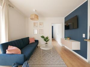 a living room with a blue couch and a table at 85qm, Parkplatz, zentral, großer Balkon, 2 Bäder in Paderborn