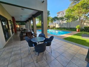 a patio with a table and chairs next to a pool at Tevin Nest 2 in Sandton