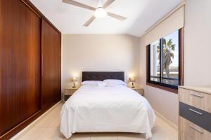 Un dormitorio con una cama y un ventilador de techo. en EDEN RENTALS Malvasia Hideaway, en El Médano