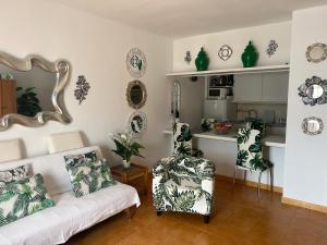 een woonkamer met een bank en een keuken bij La casita de la piscina in Adeje