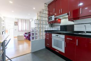 uma cozinha com armários vermelhos e um forno de fogão branco em rentafive Vistas al mar Bungalow BBQ em Santa Pola