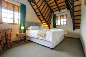 a bedroom with a large white bed and windows at 19 Mount Champagne in Winterton