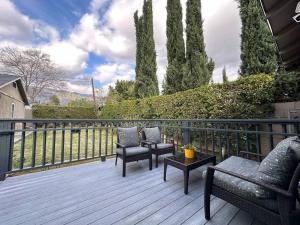 a wooden deck with chairs and a table on a balcony at Mins To Pasadena Charm & Rose Bowl in Altadena