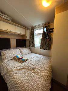 Un dormitorio con una cama con un libro. en CARAVAN NICKY, en Meliden