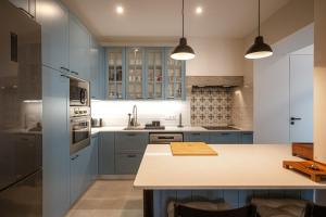 シントラにあるCasa Nª Srª das Graçasの青いキャビネットとカウンタートップを備えたキッチン