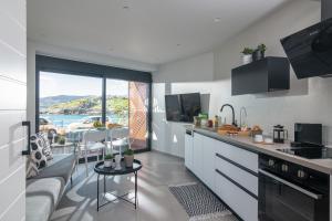a kitchen and living room with a view of the ocean at Beachfront Salty Sea Luxury Suite 2 in Agios Nikolaos