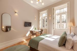 Un dormitorio con una cama, un espejo y una mesa. en Living Valverde Studios - Minho's Guest, en Braga