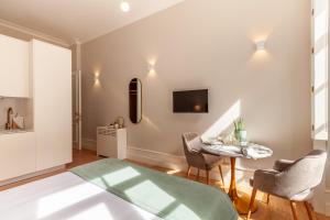 Una sala de estar con una mesa y sillas y un televisor. en Living Valverde Studios - Minho's Guest, en Braga
