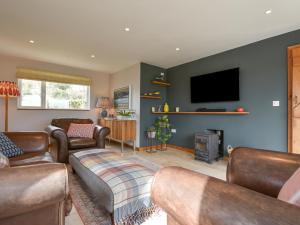 a living room with leather furniture and a flat screen tv at Orchard View in South Pool